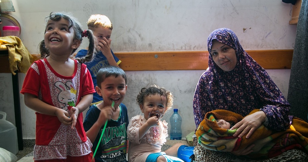 Großfamilie mit Neugeborenem in einer Notunterkunft / Copyright 2014, KNA GmbH, www.kna.de, All Rights Reserved, Andrea Krogmann Die kleine Bisan wurde am ersten Kriegstag in einer UNRWA-Schule in Gaza geboren, in die sich die Familie in Sicherheit vor den Luftangriffen gebracht hat. Die Großfamilie lebt mit 45 Personen in einem Klassenzimmer der Schule.