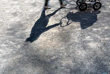 Schatten eirn Frau mit einem Kinderwagen. 